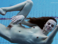 Стройнявая девка плавает и обнажается под водой в бассейне
